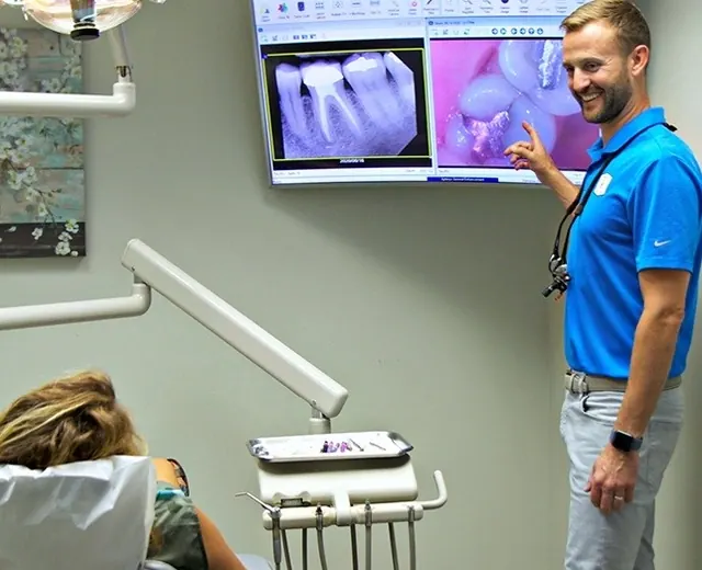 Dr. Hickey showing a patient her digital x-ray and intraoral images on a screen.