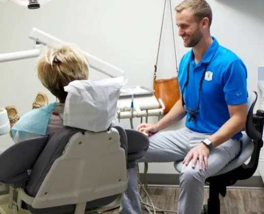 Dr. Hickey talking with a patient in the treatment chair.