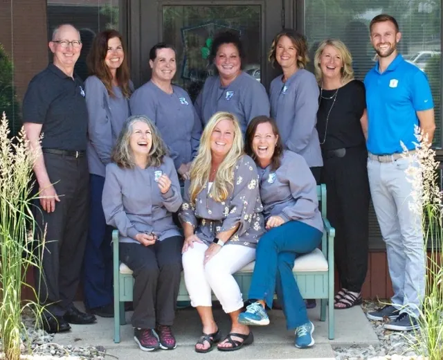 The Granger Dental Group team together on a bench outside the office.