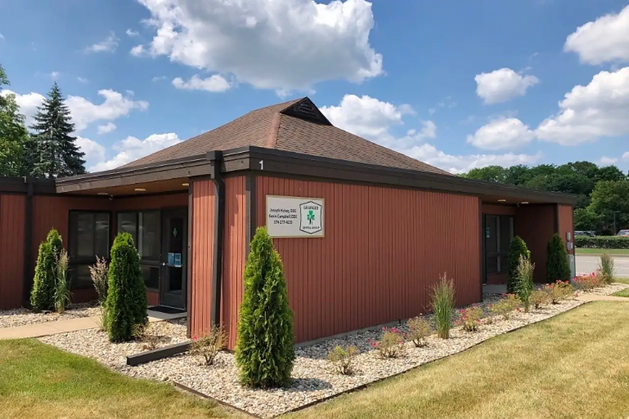 Granger Dental Group's wooden office building on N Main Street in Granger, Indiana, under a blue summer sky.