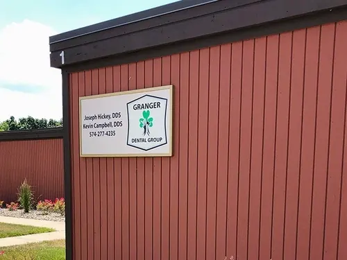 The Granger Dental Group sign on the side of the practice's red wooden building, naming Dr. Joseph Hickey and Dr. Kevin Campbell.
